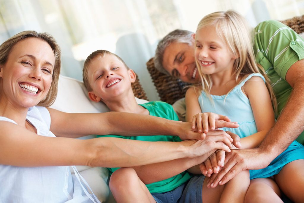 Family stacking hands and having fun